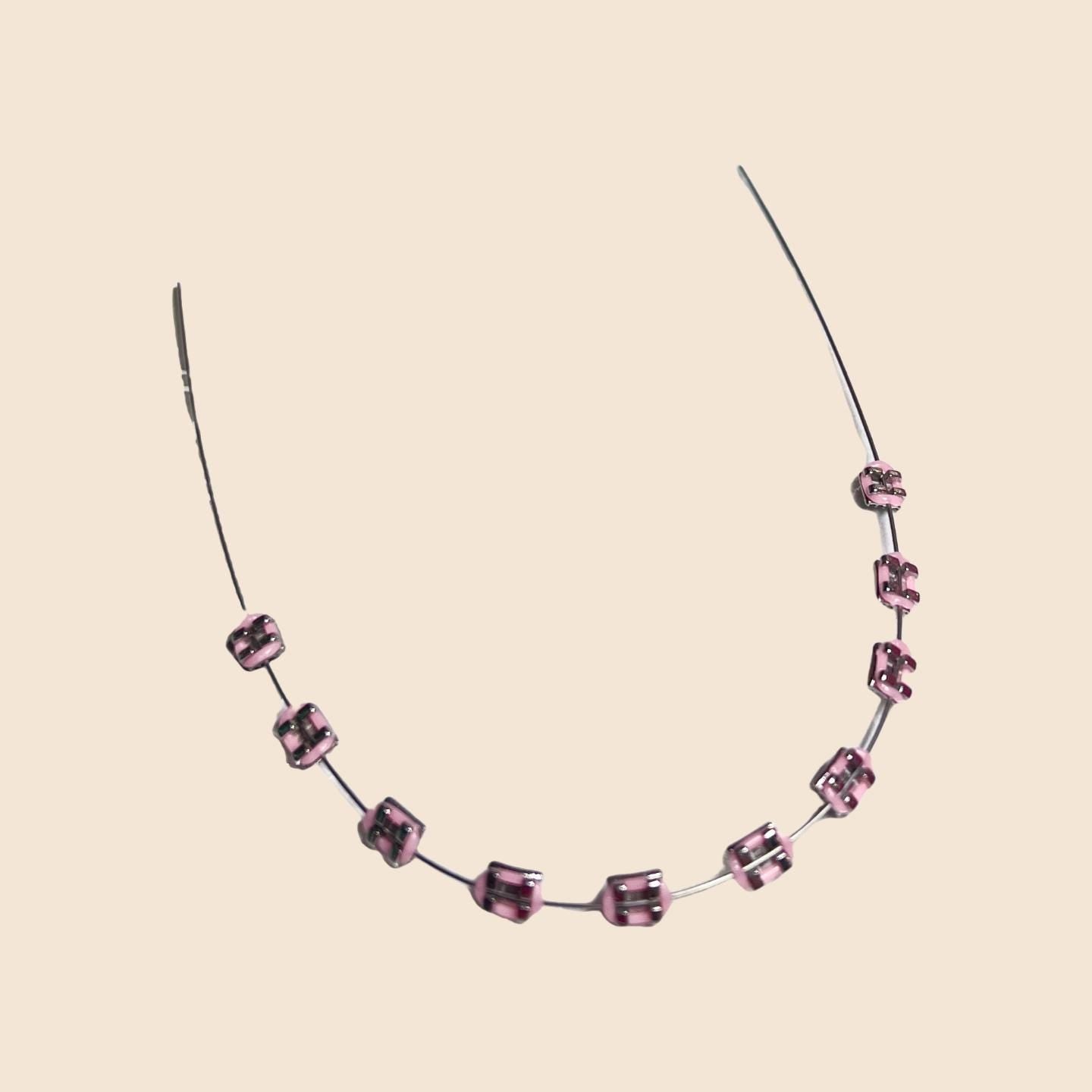 Pink handmade doll braces with glossy metallic brackets arranged on wire, shown as a color option in a DIY cosplay tooth accessory kit for The monster Labubu dolls. Adhesive tools included. Doll not included.