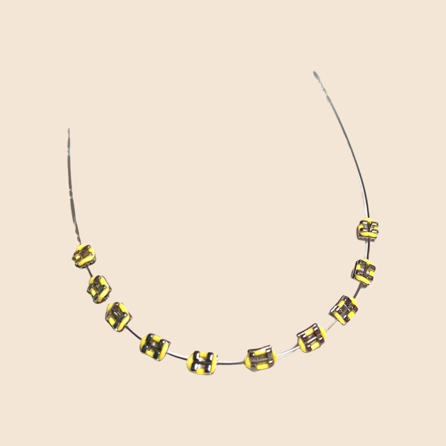 Yellow handmade doll braces with glossy metallic brackets on a wire, shown as a color variant in a DIY cosplay accessory kit for The monster Labubu Doll . Adhesive tools included. Doll not included.