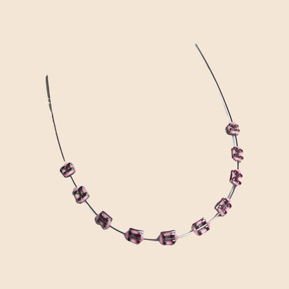 Pink handmade doll braces with glossy metallic brackets arranged on wire, shown as a color option in a DIY cosplay tooth accessory kit for The monster Labubu dolls. Adhesive tools included. Doll not included.